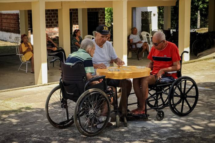 Moradores jogando dominó na varanda coberta