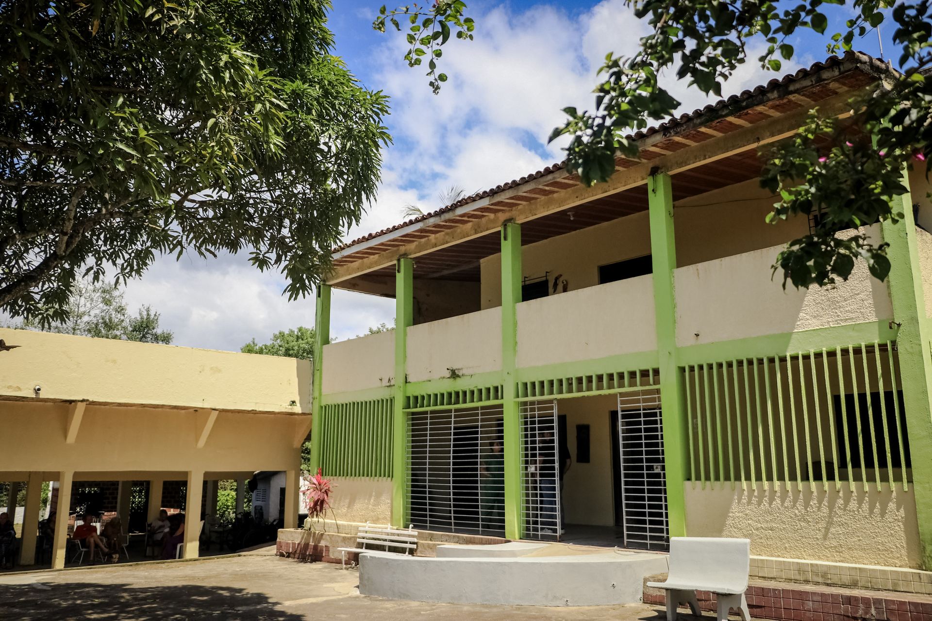 Fachada lateral da Aquarela Pousada Geriátrica, com varanda em verde e detalhes em amarelo